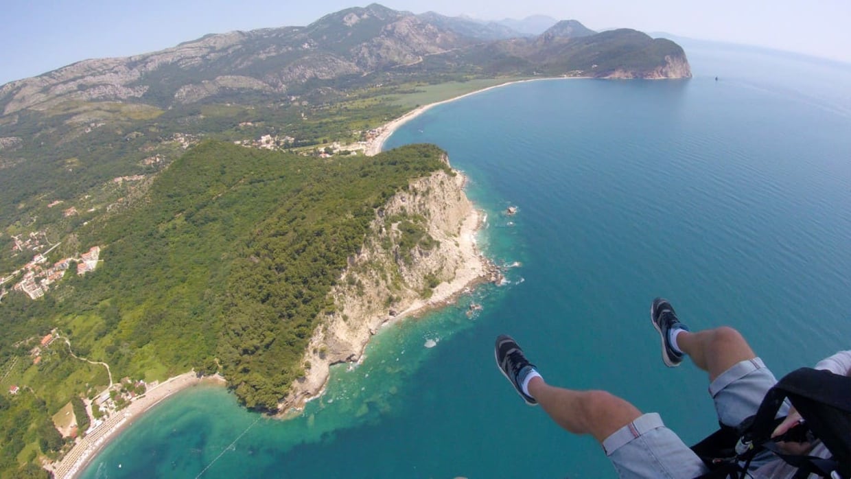 Paragliding above Petrovac with mountain-to-sea views over Lucica and Buljarica bays